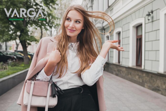 cute attractive stylish smiling woman walking city street in pink coat spring fashion trend holding purse, elegant style