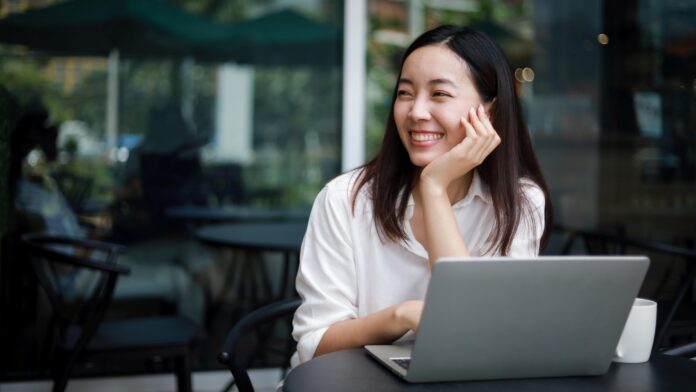 Asian woman working with computer laptop and drinking coffee in